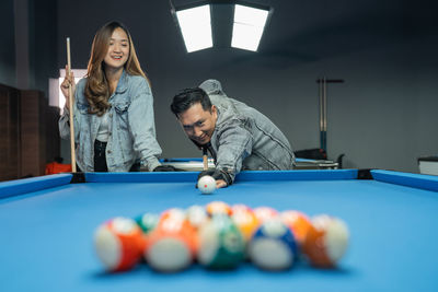 Midsection of woman playing pool