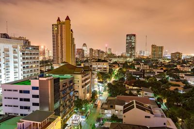 Illuminated cityscape against sky at dusk