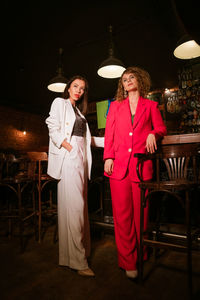 Two beautiful women posing at the bar in the evening