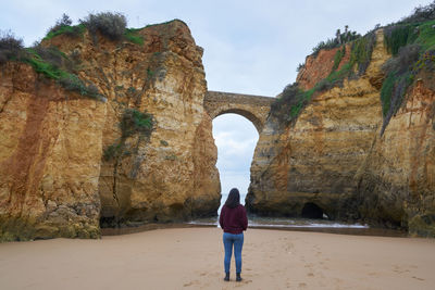 Rear view of woman standing on rock