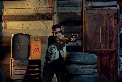 Young man pointing gun at shooting range