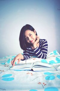 Portrait of smiling young woman against white background