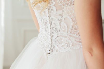 Midsection of bride wearing wedding dress during ceremony