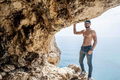 Man standing on rock by sea