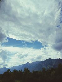 Scenic view of mountains against cloudy sky