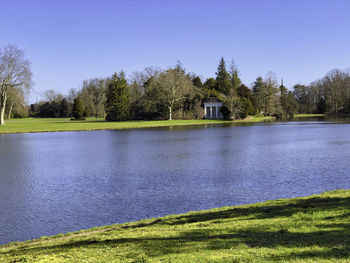 Scenic view of lake by building against sky