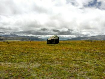 Scenic view of field and mountains against sky