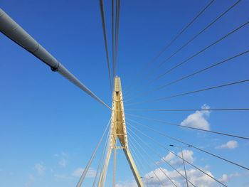 Low angle view of suspension bridge against clear blue sky