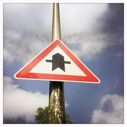 Low angle view of sign board against sky