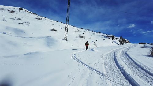 People skiing on snowcapped mountain against sky