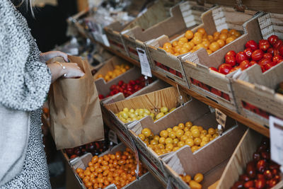 Woman in shop choosing tomatoes