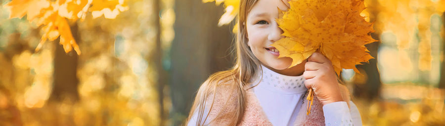 Portrait of smiling girl holding leaves