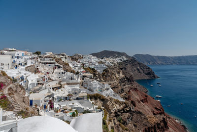 Panoramic view of sea and buildings against clear blue sky