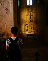 Rear view of man standing in temple