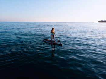 Man in sea against clear sky