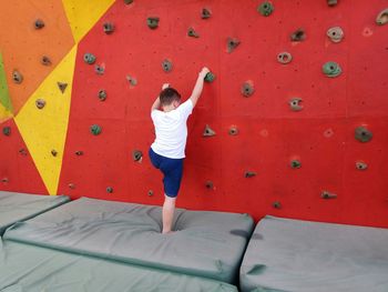Rear view of boy climbing wall