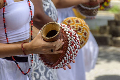 Woman playing a type of rattle called xereque of african origin used in brazil during samba 