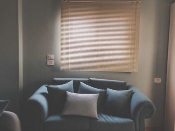 Cushions on sofa by window at home