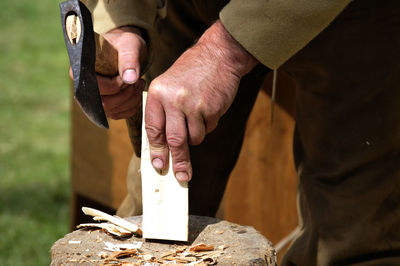 Midsection of man working on wood
