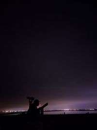 Silhouette statue against sky at night