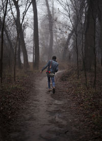 Man riding motorcycle on dirt road in forest