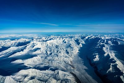 Scenic view of snowcapped mountains against blue sky