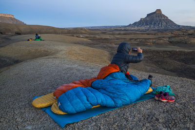 People photograph sunrise from camp in factory butte badlands, utah