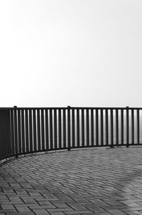 Footpath by sea against clear sky