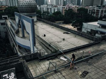 Rear view of woman standing on building terrace in city