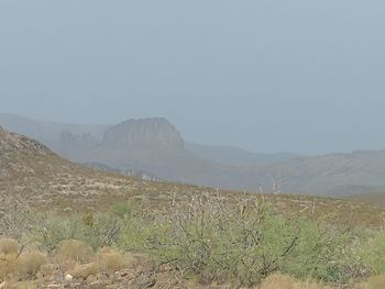 Scenic view of field and mountains against clear sky