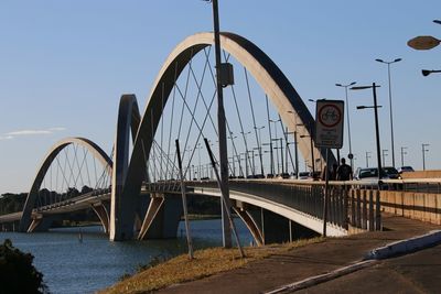 Bridge over river against sky in city