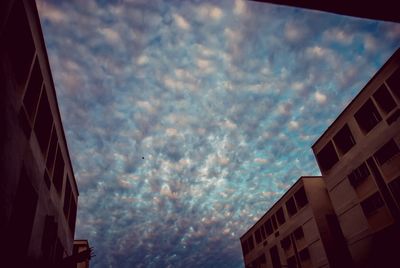 Low angle view of buildings against cloudy sky