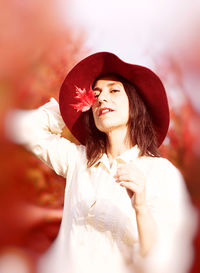 Young woman wearing hat standing against sky