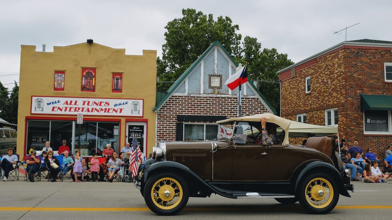 PEOPLE ON CAR AGAINST HOUSE