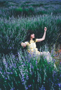 Full length of woman with pink flowers on field