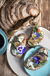 Delicious bruschetta with homemade bread, garnished with fig,soft cheese,pansies