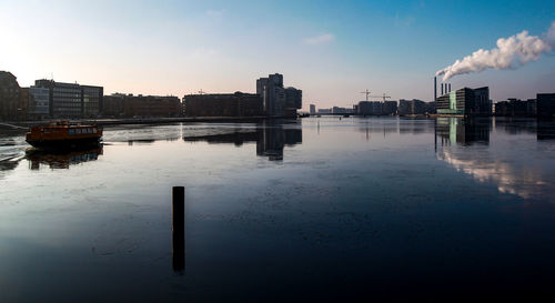 Reflection of buildings in water against sky