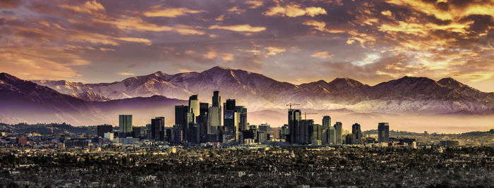 Panoramic view of buildings in city against sky during sunset