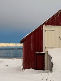 Built structure on snow covered land against sky