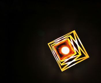 Close-up of illuminated lamp against black background