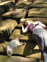 Full length of woman relaxing on land by monkey 