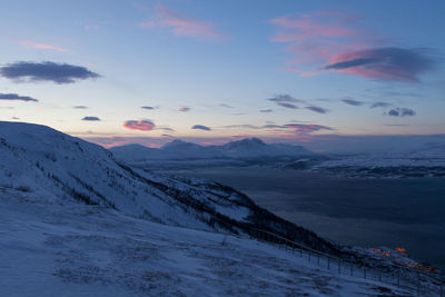 Idyllic shot of fjord with snowcapped mountains against sky