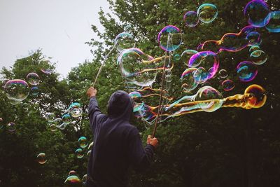 Rear view of man playing with bubbles