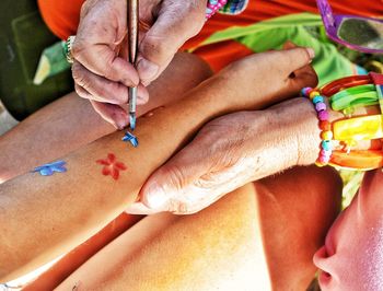 Close-up of young woman getting floral arm painting