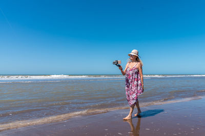 Rear view of woman standing at beach