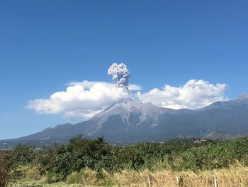 Scenic view of mountains against blue sky