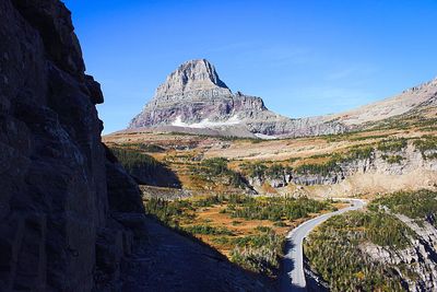 Scenic view of rocky mountains against blue sky at glacier national park