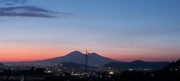 Silhouette buildings in city against sky during sunset