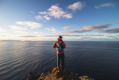 Backpacker at 24 years old stands on edge of cliff in a place called cristo rei, lomos, madeira