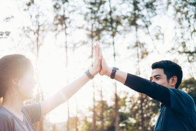 Friends standing by tree against plants